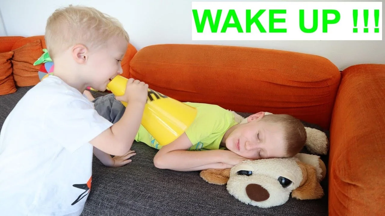 Mike wakes up Jake with toy musical instruments 